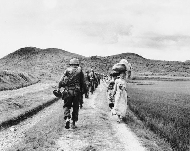 Korean War refugees passing servicemen (PC: National Archives)