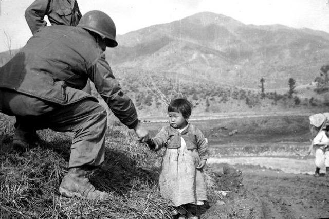 American soldier gives candy to a Korean child during the Korean War