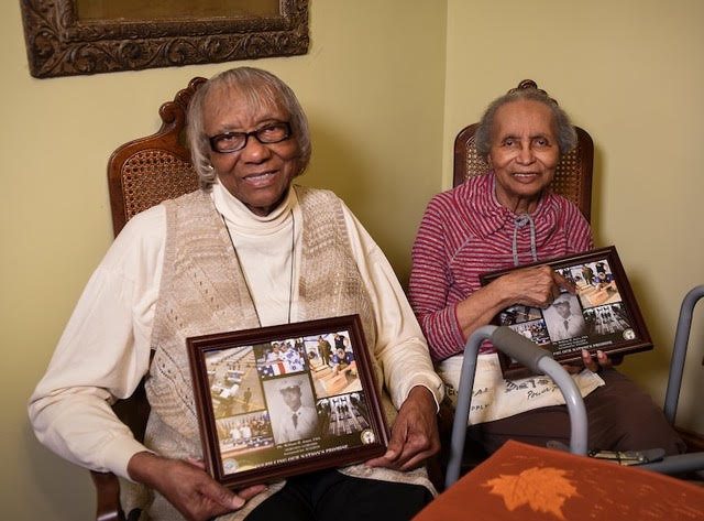 Ida Jones-Dickens, left, and Elizabeth Jones-Ohree hold collages of their brother presented to them by the Defense POW/MIA Accounting Agency, November 2018. (PC:U.S. Air Force, Staff Sgt. Apryl Hall)